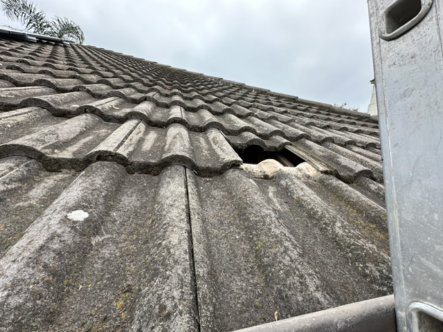 Cracked and displaced roof tiles before repair