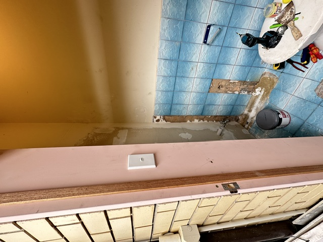 Old toilet room mid-demolition, dated blue tiles